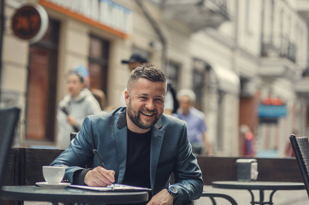 Cute man smiling emotions.Businessman writes on documents puts signatures. - Fotografie, Obrázek
