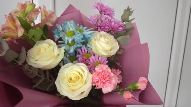 Κοντινό πλάνο ενός όμορφου μπουκέτο διαφορετικών λουλουδιών σε ένα φωτεινό ροζ πακέτο. - Πλάνα, βίντεο