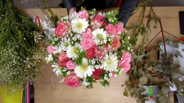 Vista superior de las manos de una florista joven creando una composición - Imágenes, Vídeo