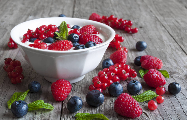 fresh berries, raspberries and blueberries on a wooden table - Fotografie, Obrázek