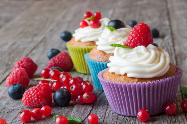 вкусные кексы с ягодами на деревянном фоне - Фото, изображение