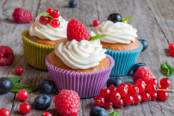 delicious cupcakes with berries on wooden background - Фото, изображение