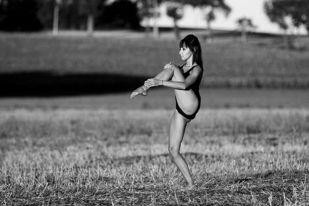 Bailarina moviéndose descalza en un rastrojo de campo
. - Foto, imagen