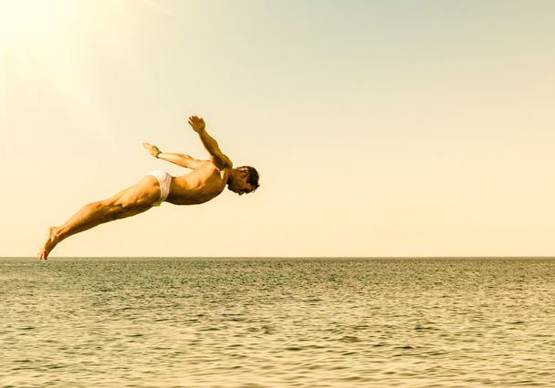 Cliff diver jumping in the sea against the sky at sunset - Conceito de liberdade e sensação despreocupada sentindo a conexão pura com a natureza
 - Foto, Imagem