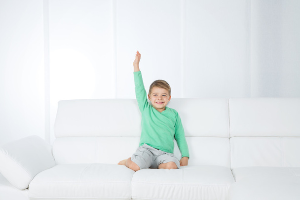 isolated young kid on white sofa - Photo, Image