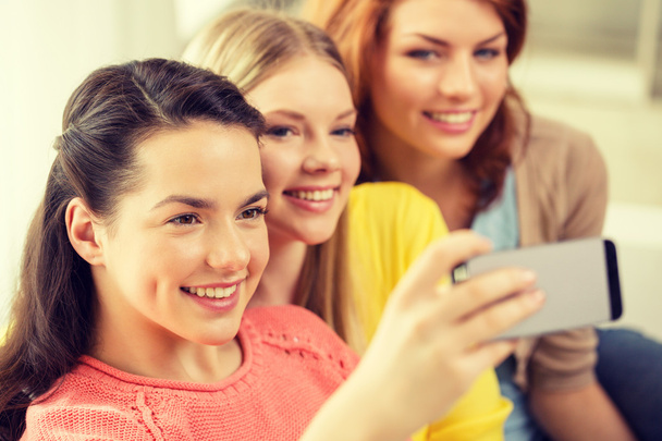 smiling teenage girls with smartphone at home - Zdjęcie, obraz