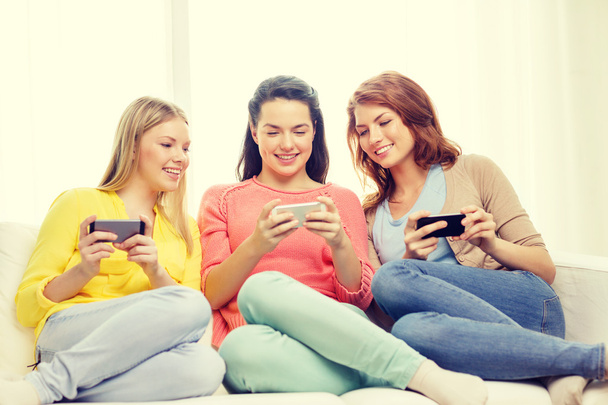 smiling teenage girls with smartphones at home - Foto, Imagen