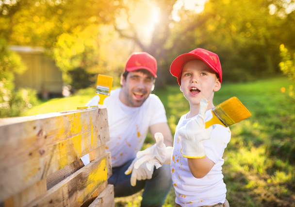 Father with son painting wooden fence - Foto, Imagen