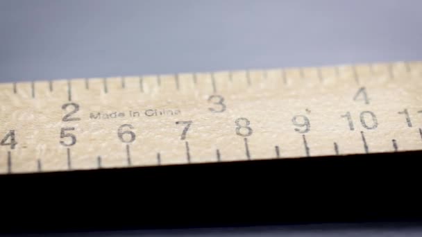 Συρόμενη μπροστά από ξύλινο χάρακα με κλίμακες για τη μέτρηση εκατοστών και ιντσών - Πλάνα, βίντεο