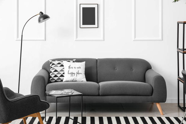 Interior elegante com sofá cinza perto da parede branca - Foto, Imagem