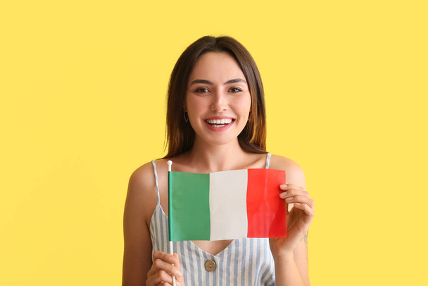 Beautiful young woman with Italian flag on yellow background - Photo, Image