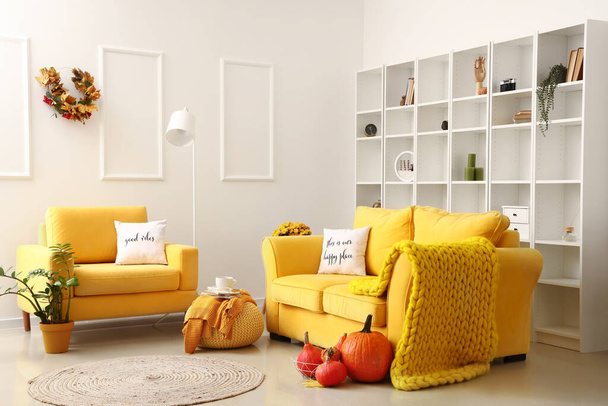 Интерьер современной гостиной с удобными диванами и тыквами - Фото, изображение