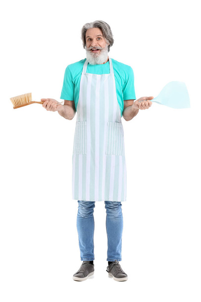 Ανώτερος άνθρωπος με σέσουλα και βούρτσα καθαρισμού σε λευκό φόντο - Φωτογραφία, εικόνα
