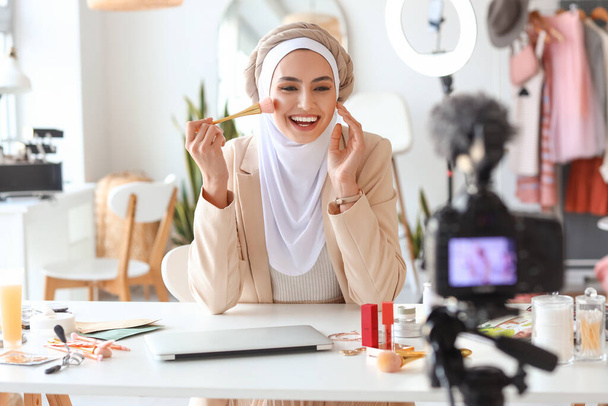 Muslim beauty blogger with brush recording video in dressing room - 写真・画像