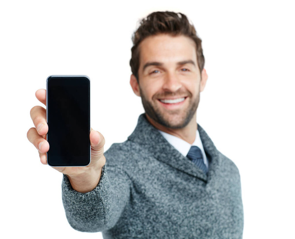 Esta es la última aplicación imprescindible. Retrato de estudio de un hombre de negocios guapo mostrando un teléfono con una pantalla en blanco sobre un fondo blanco. - Foto, imagen