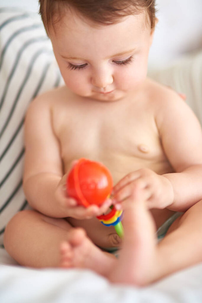 Hmmhow does this work. Cropped shot of an adorable baby girl playing with a toy. - Photo, Image