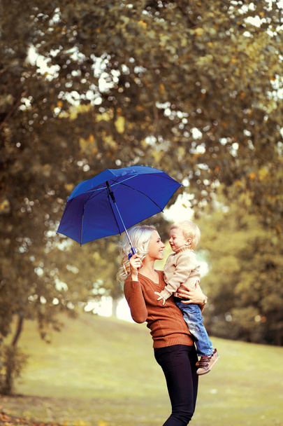 Happy mother and baby having fun in autumn day - Foto, afbeelding