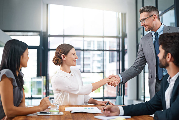 I know youll be a great asset to the company. Cropped shot of two businesspeople shaking hands during a meeting in the boardroom. - Foto, imagen