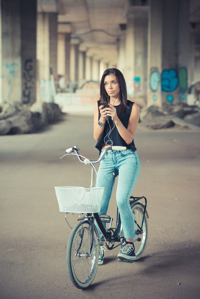 νέοι όμορφη μελαχρινή με ίσια μαλλιά γυναίκα που χρησιμοποιούν ποδήλατο και smar - Φωτογραφία, εικόνα