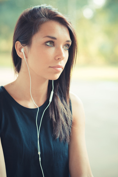 音楽を聴く若い美しいブルネット ストレートの髪の女性 - 写真・画像