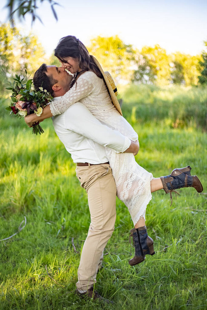 el novio sostiene a la novia en sus brazos
 - Foto, imagen
