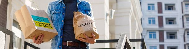un hombre sostiene una caja con ayuda humanitaria a Ucrania - Foto, imagen