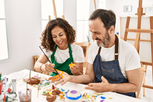Студент двох середнього віку посміхається щасливим живописом в художній студії
. - Фото, зображення