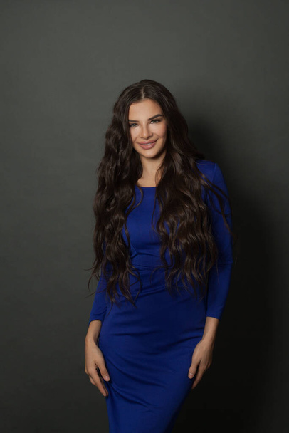 Beautiful woman fashion model brunette wearing blue dress in casual style on black - Photo, image