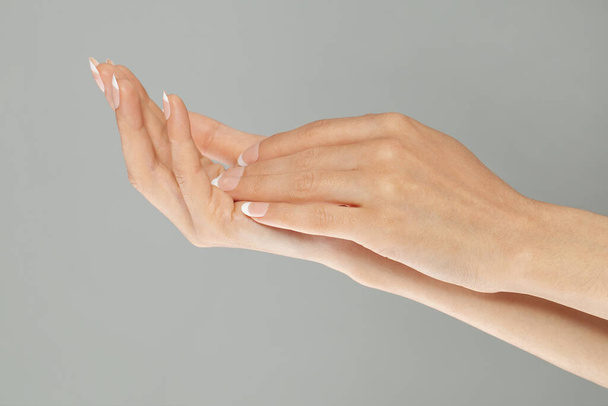 Il concetto di manicure. Due mani femminili con unghie curate perfette con manicure francese - Foto, immagini