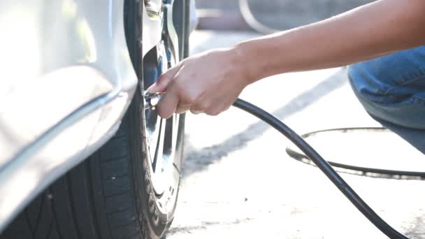 Close up,woman checking pressure and inflating car tire. - Footage, Video