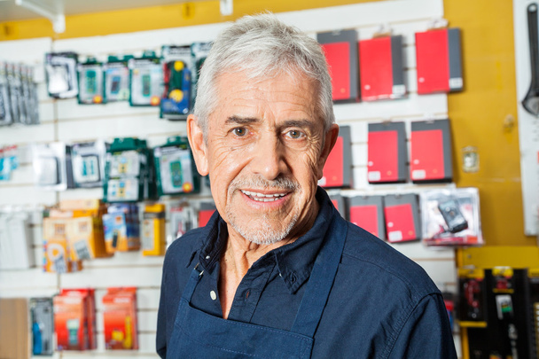 Confident Senior Worker Smiling In Hardware Shop - Фото, изображение
