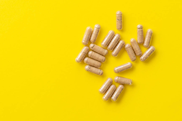 yellow pills on a green background. top view. - Foto, Imagem
