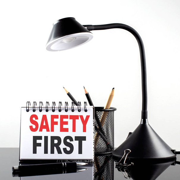 Siyah arkaplanda kalem ve masa lambası olan bir deftere ilk güvenli metin - Fotoğraf, Görsel