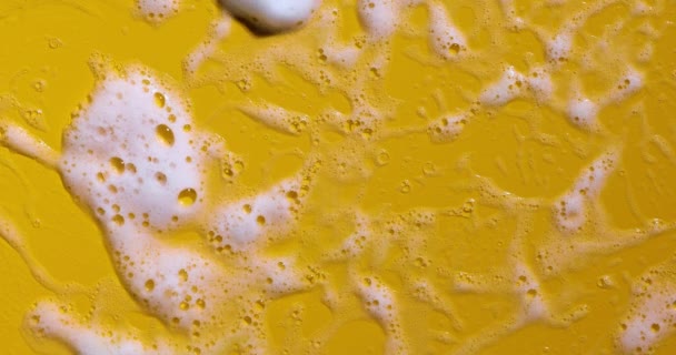 Textura de espuma de jabón blanco con burbujas fondo amarillo abstracto, jabón, gel de ducha, champú, muestra de mousse limpiador de crema facial. - Imágenes, Vídeo