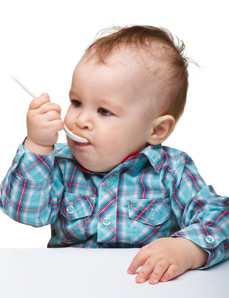 Cute little boy is biting spoon - Foto, immagini