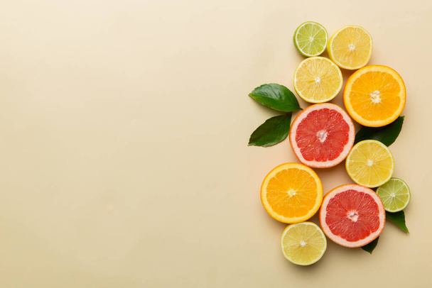 Fruit background. Colorful fresh fruits on colored table. Orange, lemon, grapefruit Space for text healthy concept. Flat lay, top view, copy space. - Photo, Image
