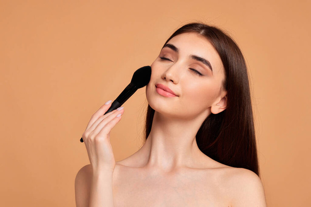 model applying powder with make-up brush - Photo, image
