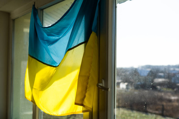 Bandiera dell'Ucraina sulla finestra sigillata con nastro adesivo. Niente guerra. Guerra in Ucraina - Foto, immagini