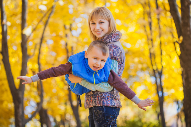 mother and her kid have fun in the autumn park - Foto, Imagem