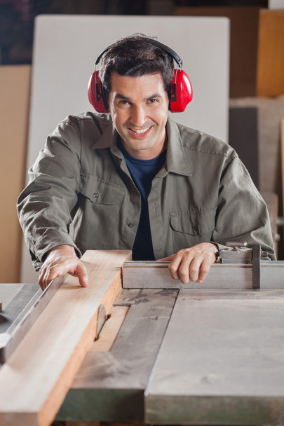 Confident Carpenter Cutting Wooden Plank With Tablesaw - Fotó, kép
