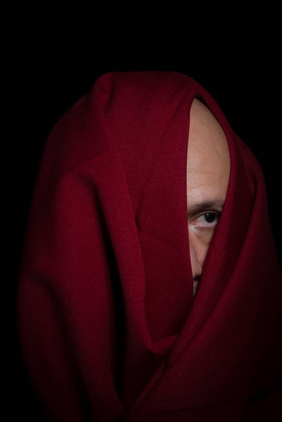 Людина вкрита червоною тканиною на чорному тлі. Сальвадор (Баїя, Бразилія).. - Фото, зображення