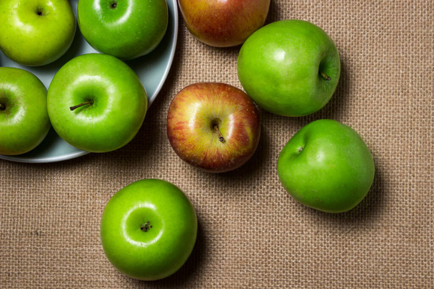 The apples lie on the burlap. Different varieties of apples. ripe fruit - Foto, Imagen