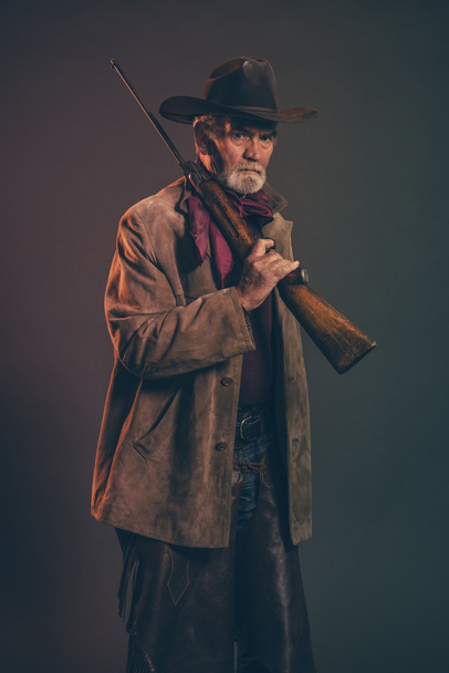 alter grober Western-Cowboy mit grauem Bart und braunem Hut - Foto, Bild