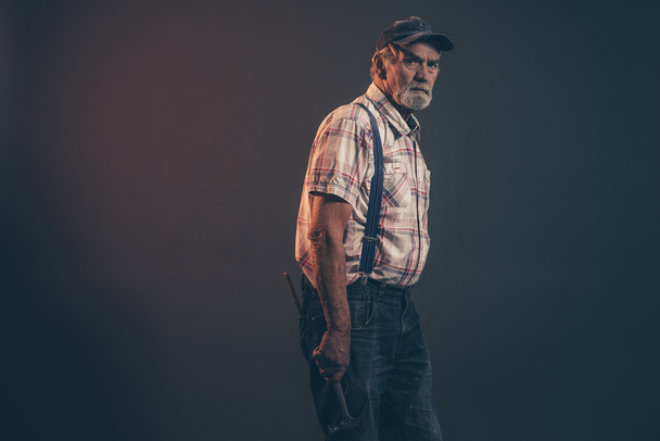 Carpintero macho mayor con pelo gris y barba sosteniendo un martillo
  - Foto, Imagen