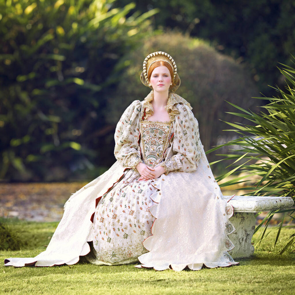 Esperando a su rey. Retrato de una mujer noble sentada al aire libre en terrenos del palacio. - Foto, imagen