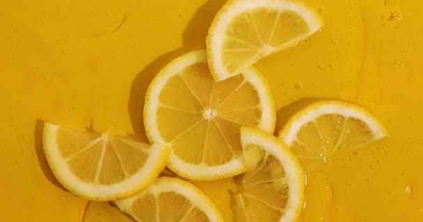 Top view rotation of fresh slice of lemons juice and gel serum, organic cosmetics, vitamin C, fresh citrus fruits, Lemon extract - Materiał filmowy, wideo
