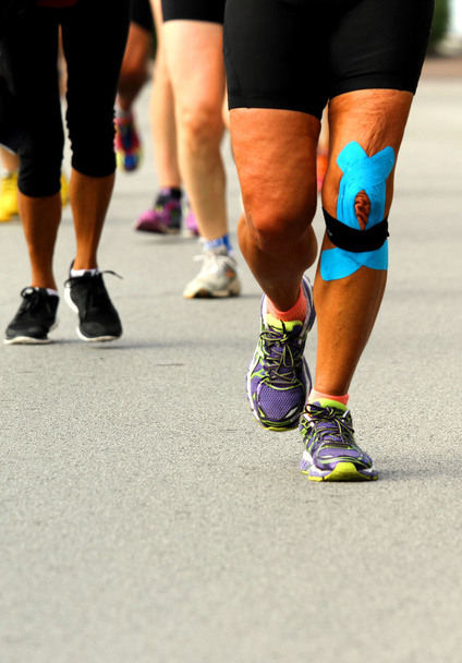 спортсмен с повязкой на колене во время маратхо
 - Фото, изображение
