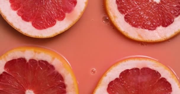 Top view rotatie van verse plak grapefruit sap en gel serum, biologische cosmetica, vitamine C, verse citrusvruchten, grapefruit extract - Video