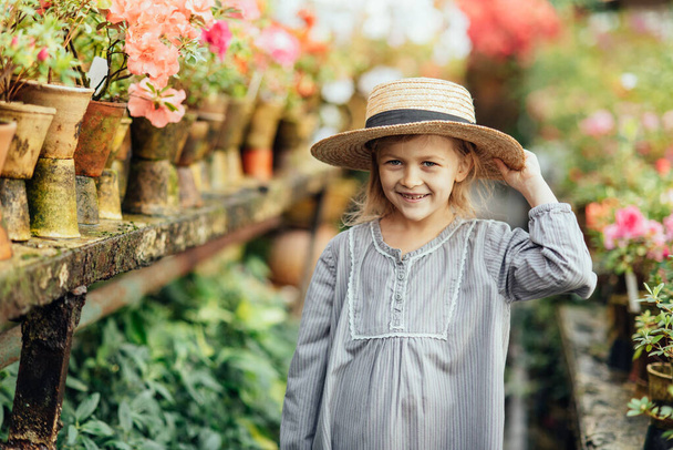 Toddler with flower basket. girl holding pink flowers - Foto, immagini