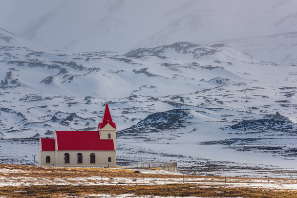 Iglesia blanca con techo rojo en el paisaje nevado de Hellisandur, Islandia - Foto, imagen